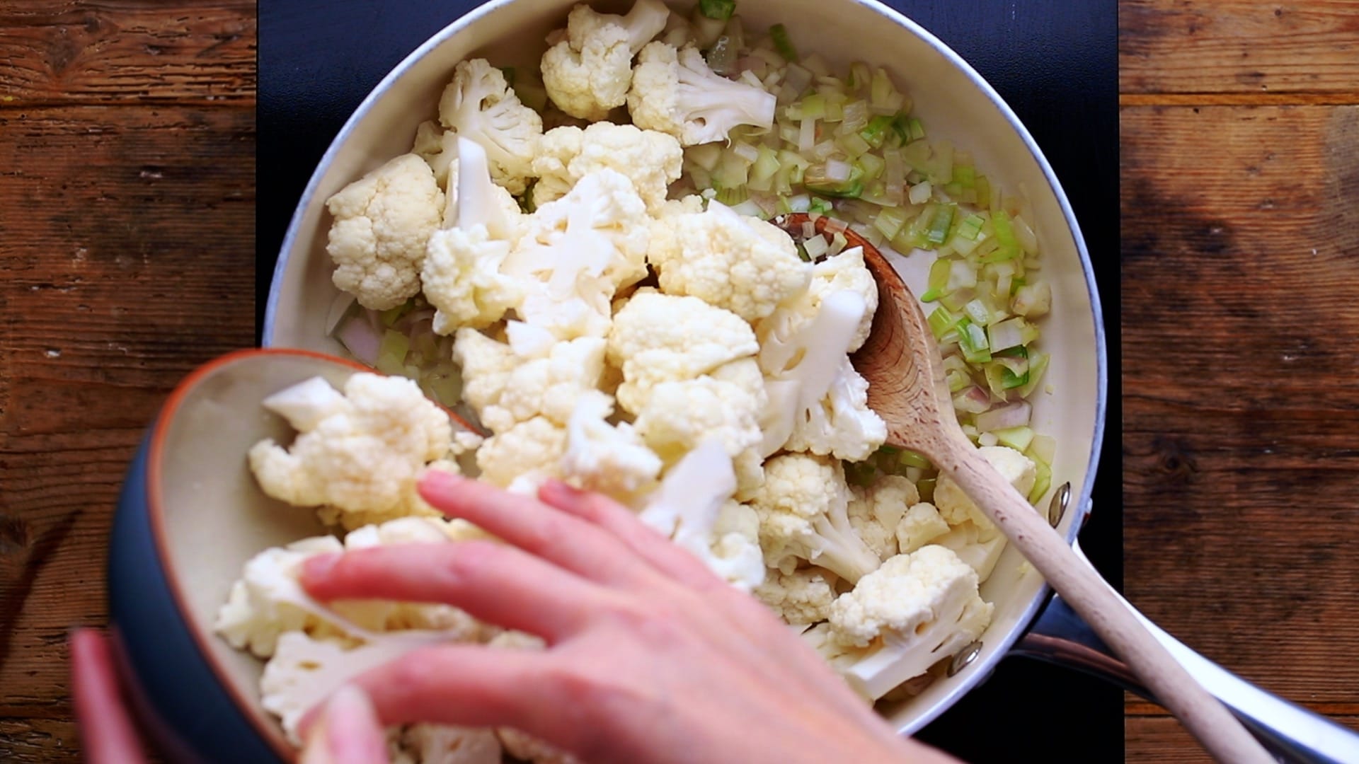 adding cauliflower florets to the fried shallots