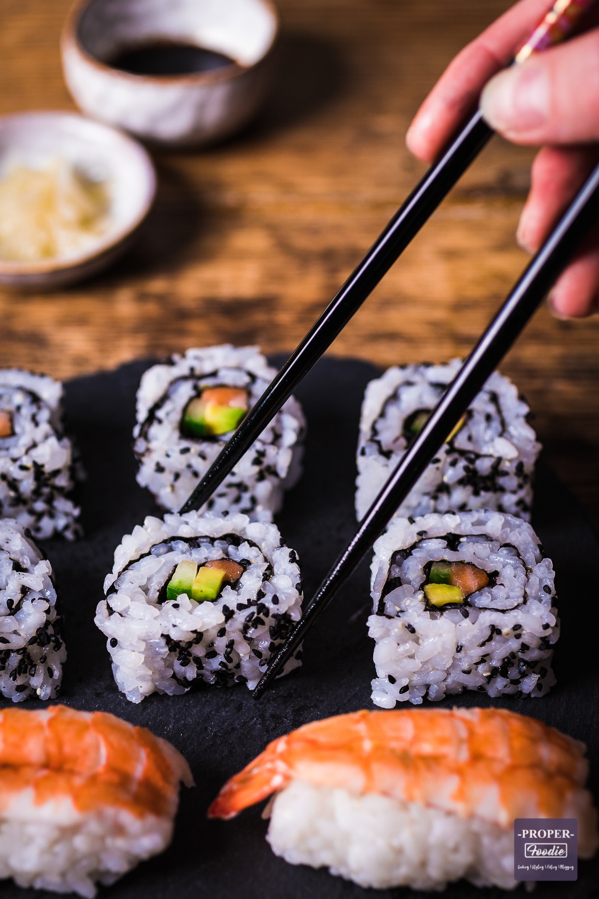 sushi roll with rice on the outside on a black slate platter