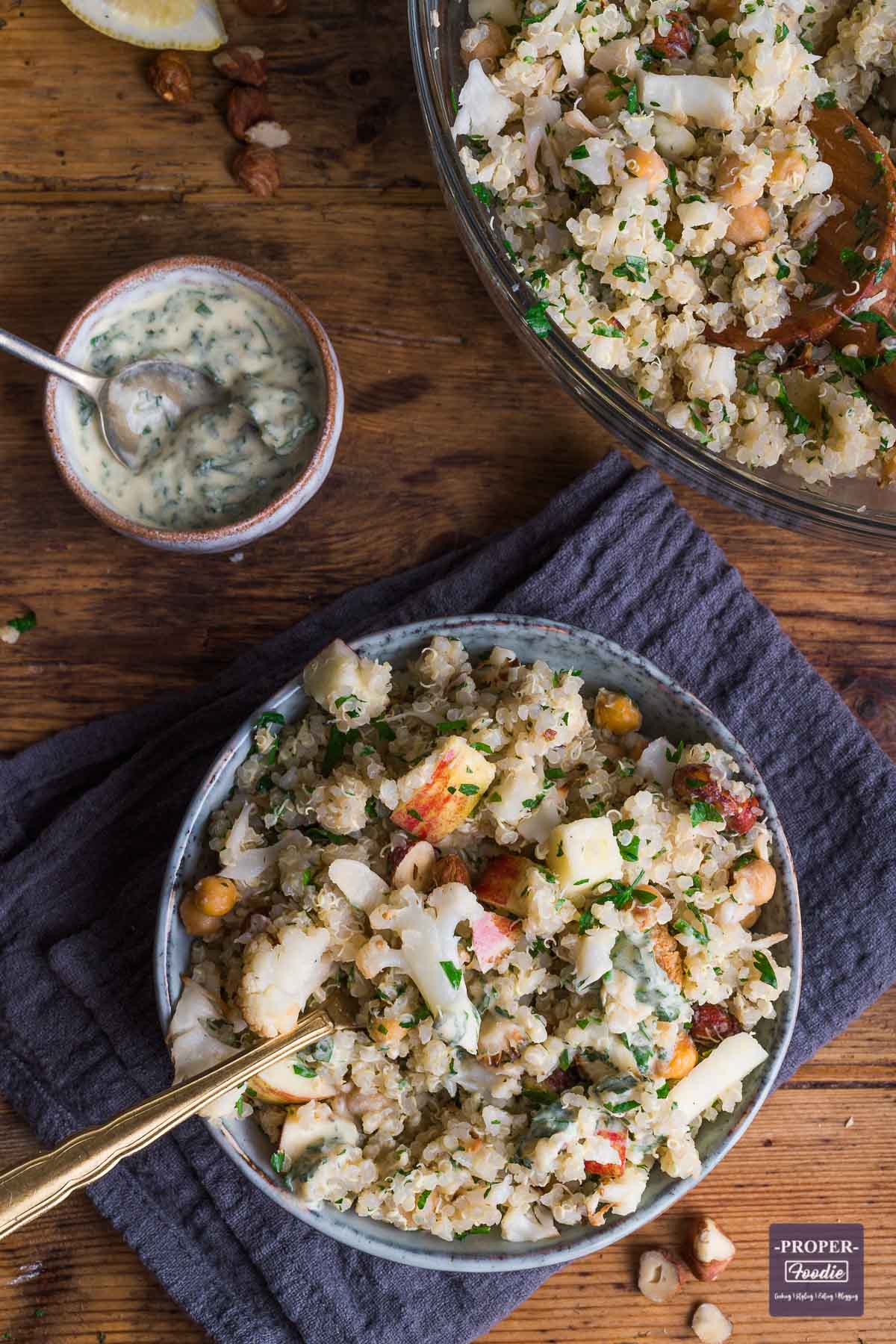 Roasted Cauliflower salad with quinoa and lemon and herb dressing served in a small bowl with part of the larger mixing bowl visible