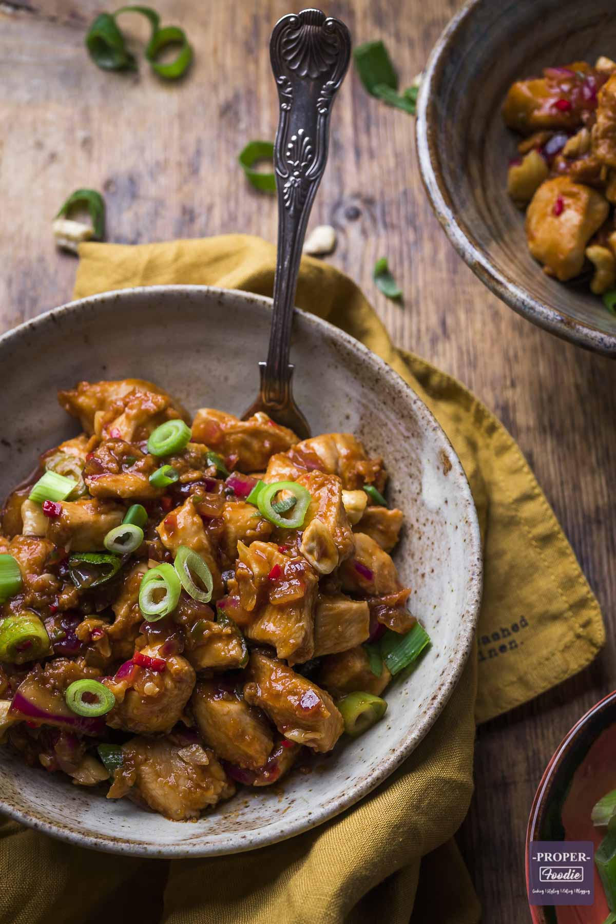 Chinese dragon chicken recipe in a bowl and topped with spring onions.