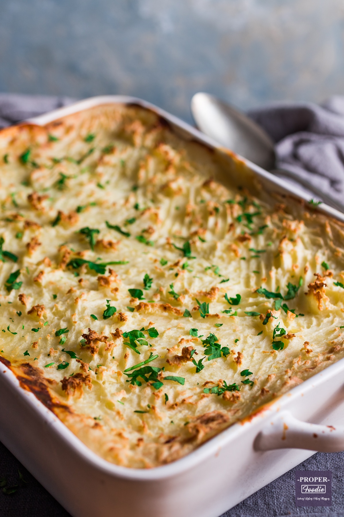 Oblong baking dish containing classic fish pie recipe with a mash potato topping that has been marked with a fork and baked until crisp.