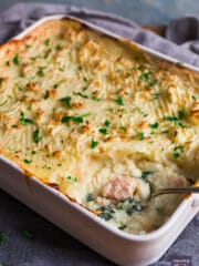 Large shallow casserole dish containing mash topped classic fish pie, baked until crisp and golden brown.