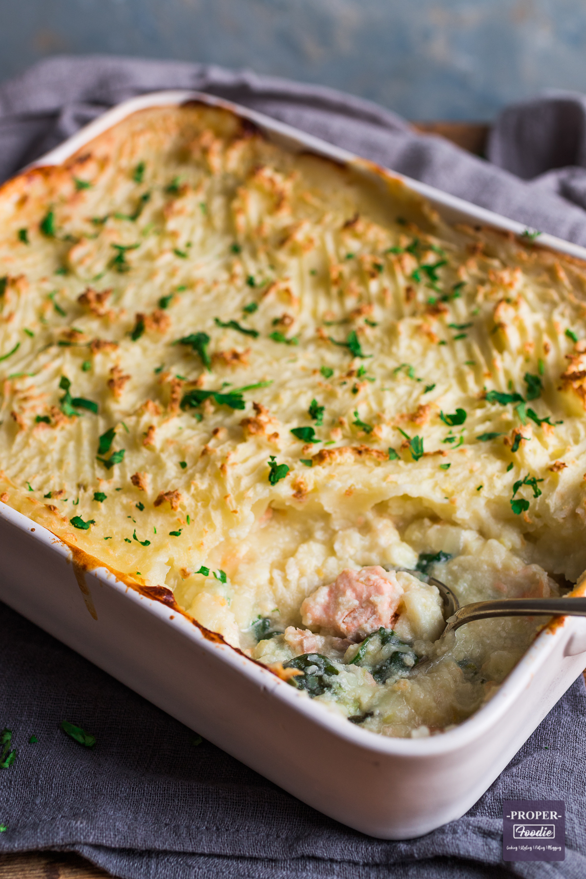 Large shallow casserole dish containing mash topped classic fish pie, baked until crisp and golden brown.