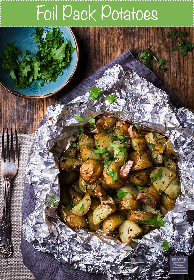 foil pack potatoes baked in the oven with garlic cloves and served with butter and parsley