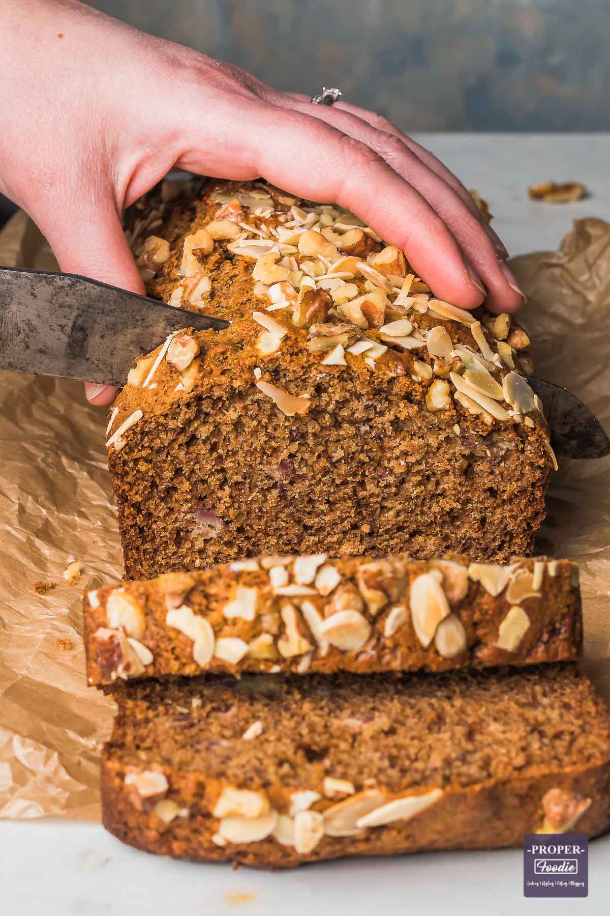 Loaf of healthy banana bread being sliced in to.