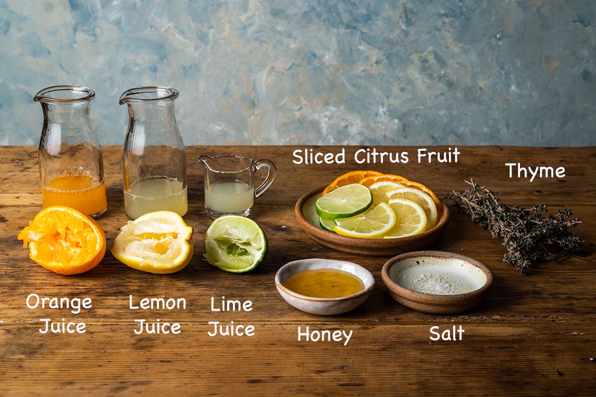 A display of all the ingredients needed to make honey and lemon tea with text overlay labelling each ingredient.