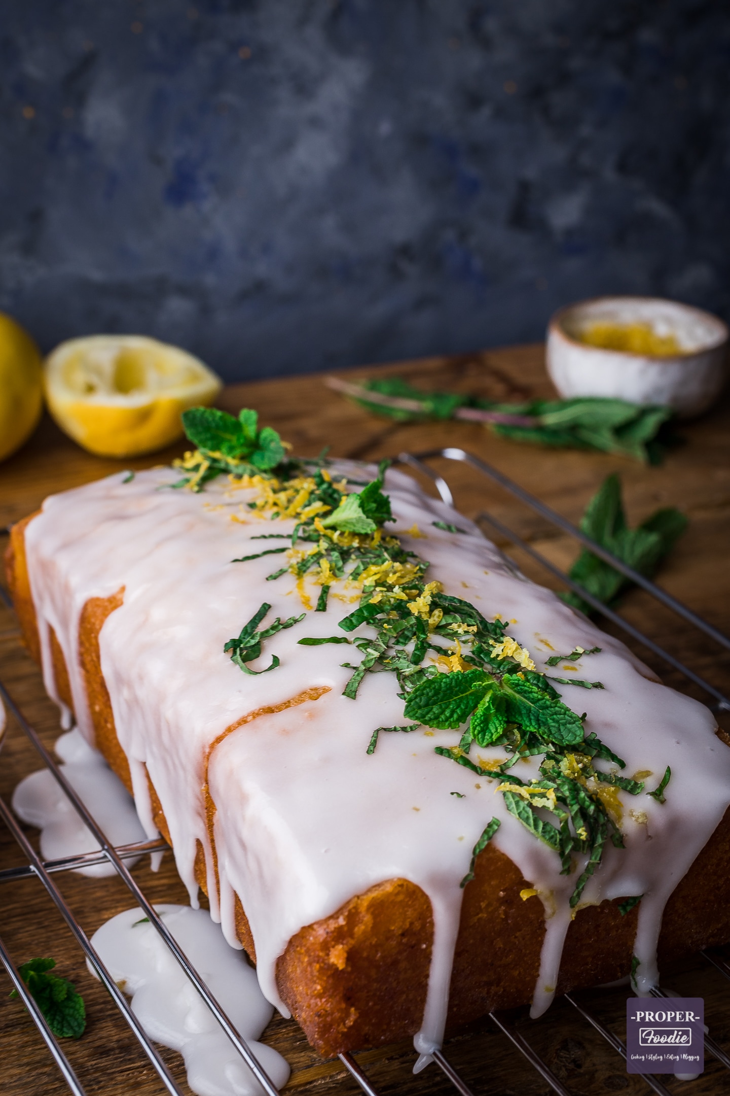 Lemon drizzle cake with lemon icing and topped with lemon zest and mint