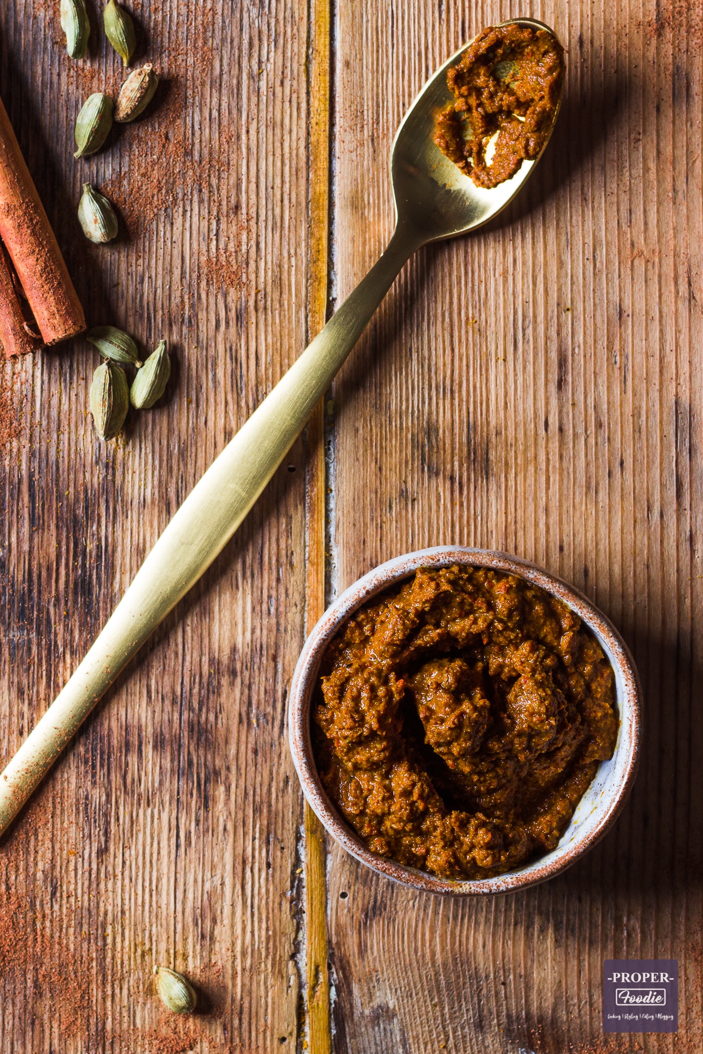 a blend of Thai ingredients in a bowl with cardamom and cinnamon at the side 