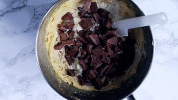 mixing flour and chocolate chunks into cookie dough mixture