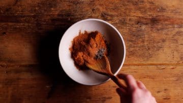 mixing spices into thai yellow paste to make massaman paste