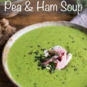 Pea and ham soup in a bowl topped with creme fraiche, chunks of ham and fresh mint