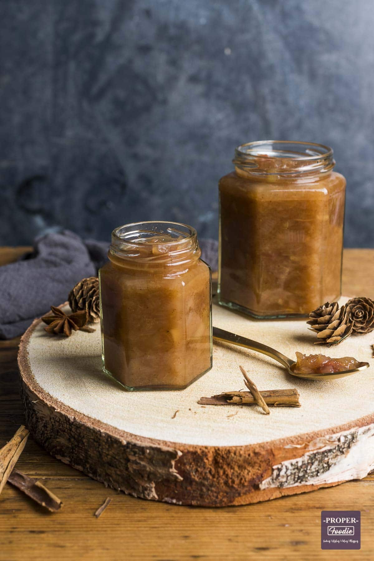 A small jar filled with homemade chutney with a larger jar of chutney in the background.