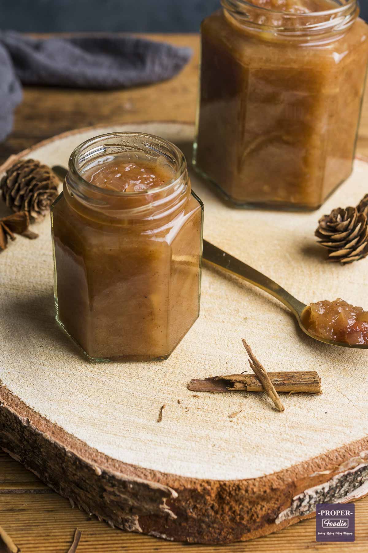 Homemade pear chutney in a small jar with the lid off and a spoonful of chutney to the side.