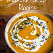 Pumpkin soup in a bowl topped with cream. Text overlay in white: 'Spiced Pumpkin Soup'.