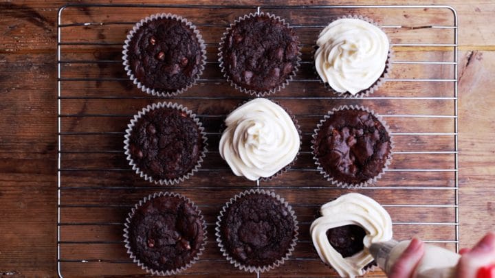 piping mascarpone cream onto chocolate muffins