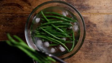 place blanched green beans in iced water to stop cooking process