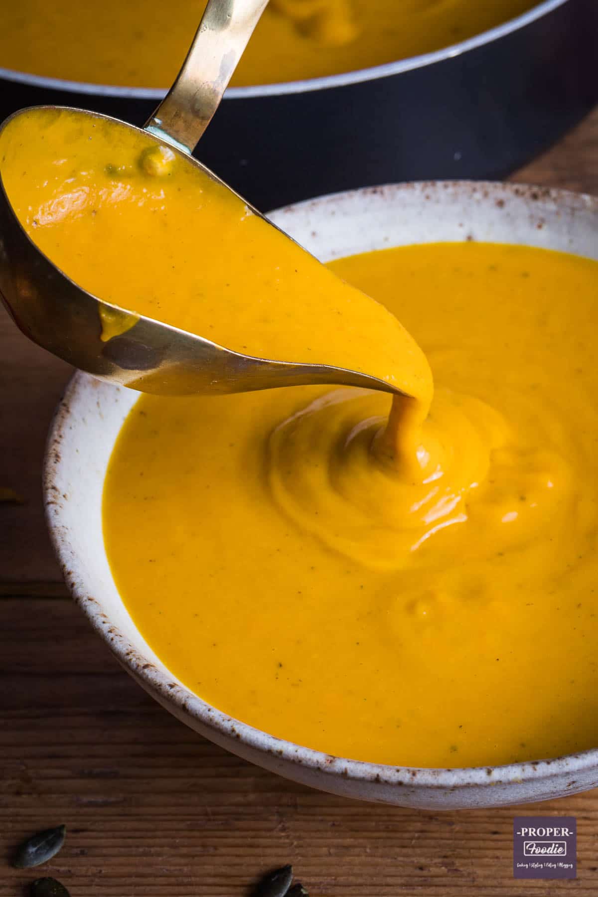 Pumpkin soup being ladled into a bowl