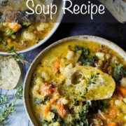 A Tuscan vegetable and bean soup served up in two bowls and topped with crusty bread, grated parmesan and fresh sprigs of thyme.