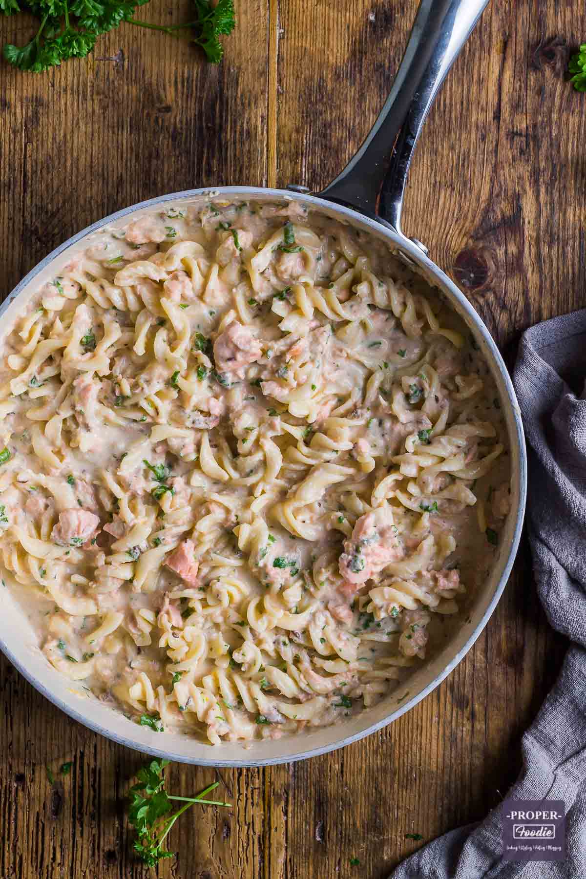 Large shallow pan filled with creamy pasta with salmon.