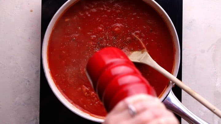 sauce simmering and black pepper being added