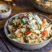 Quinoa and roasted cauliflower salad with lemon & herb dressing, served in a small bowl sat on a blue napkin.