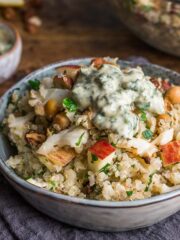 Quinoa and roasted cauliflower salad with lemon & herb dressing, served in a small bowl sat on a blue napkin.