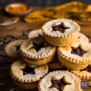 A stack of homemade mince pies with star shapes cut out of the pastry lids.