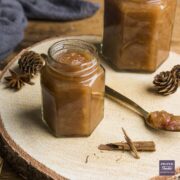 Homemade pear chutney in a small jar with the lid off and a spoonful of chutney to the side.