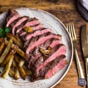 Rump steak cooked medium-rare. sliced into strips and resented on a plate with home made chips on the side.