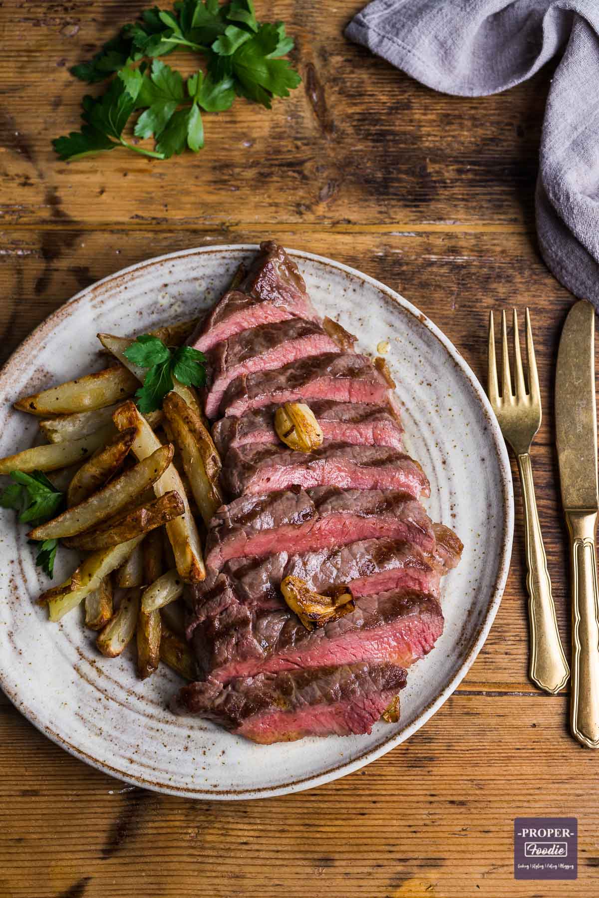 Rump steak cooked medium-rare. sliced into strips and resented on a plate with home made chips on the side.