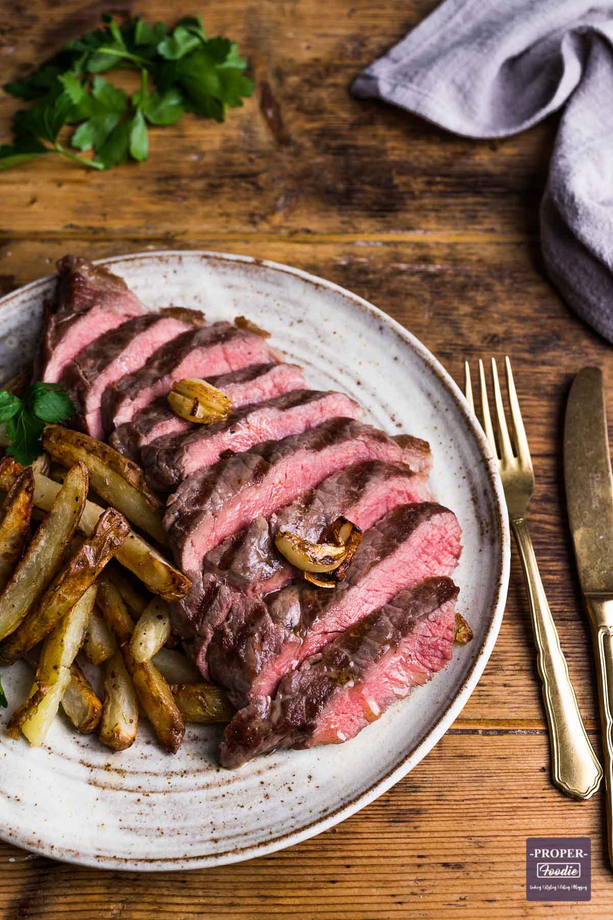 Rump steak cooked medium-rare. sliced into strips and resented on a plate with home made chips on the side.