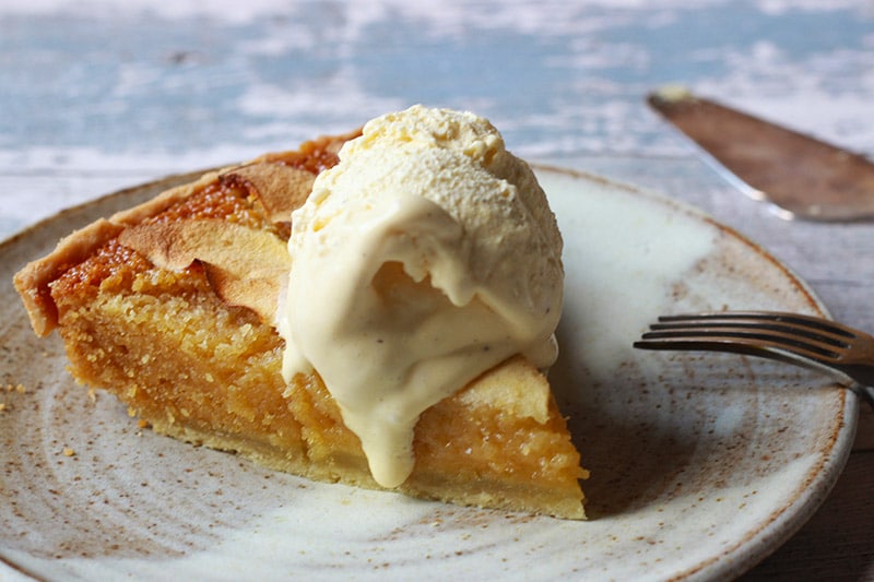 sticky apple treacle tart slice with vanilla ice cream