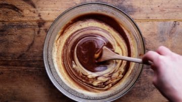 stirring melted chocolate into the whisked sugar and eggs