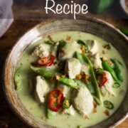 A bowl of Thai green chicken curry with mangetout, green coconut sauce and topped with sliced green chillies and crispy onions.