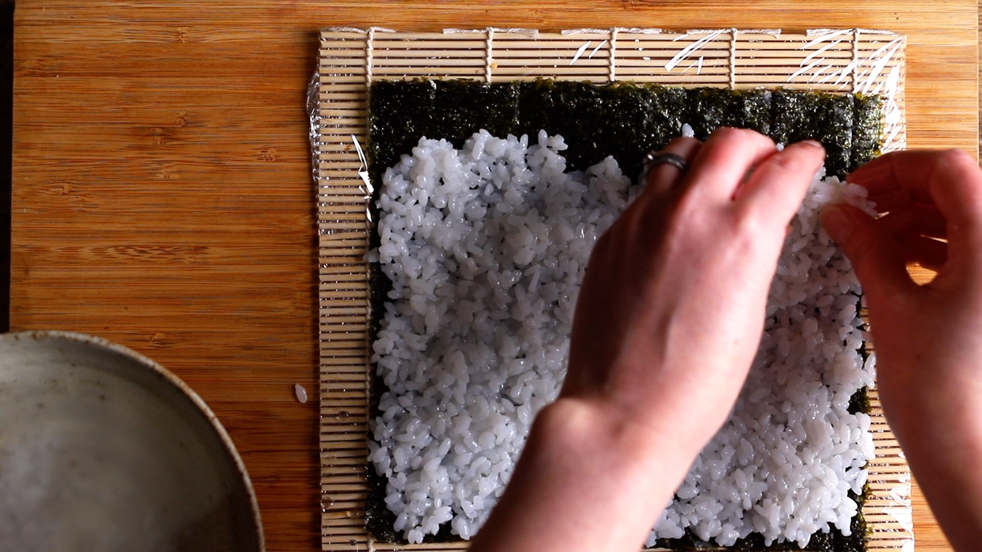 thin layer of rice on rough side of seaweed sheet